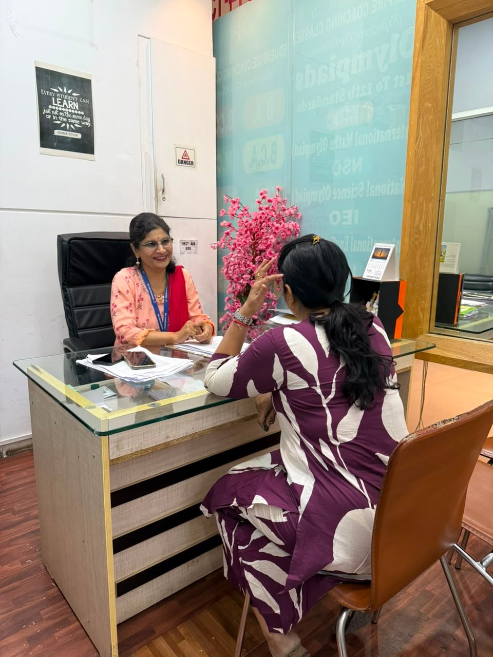 An EduEmpire faculty member reviewing a student's progress with a parent